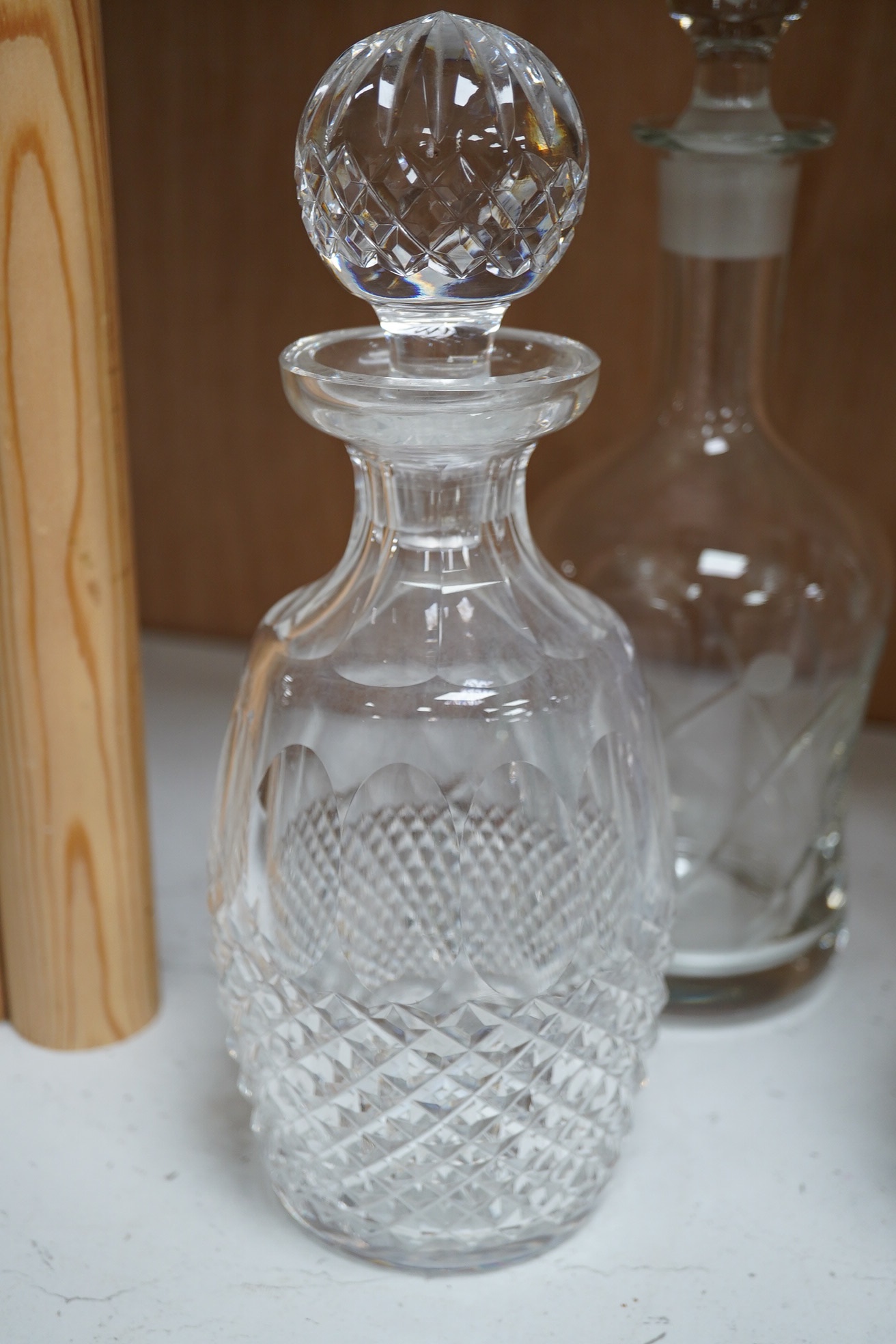 Six 19th century and later cut glass decanters and stoppers, one with white metal acorn design collar, largest 37cm high. Condition - fair, some chipping / impact damage